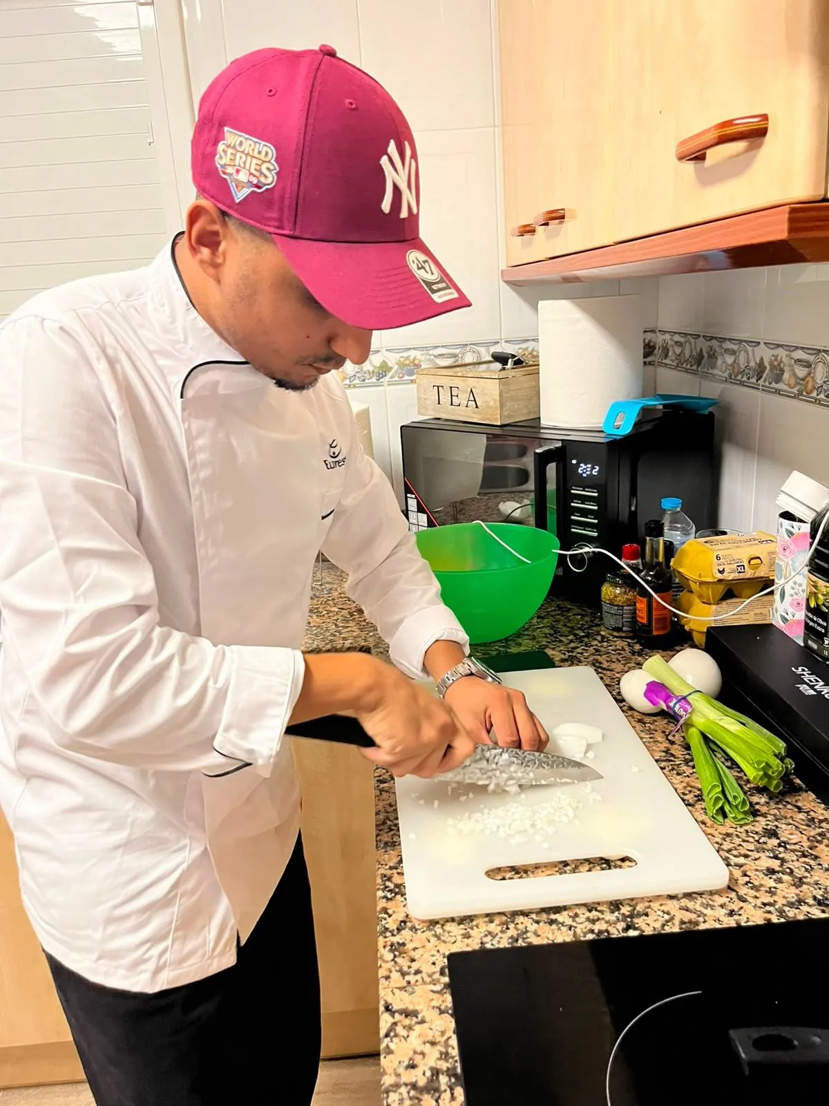 Moneim cocinando en la cocina de un cliente