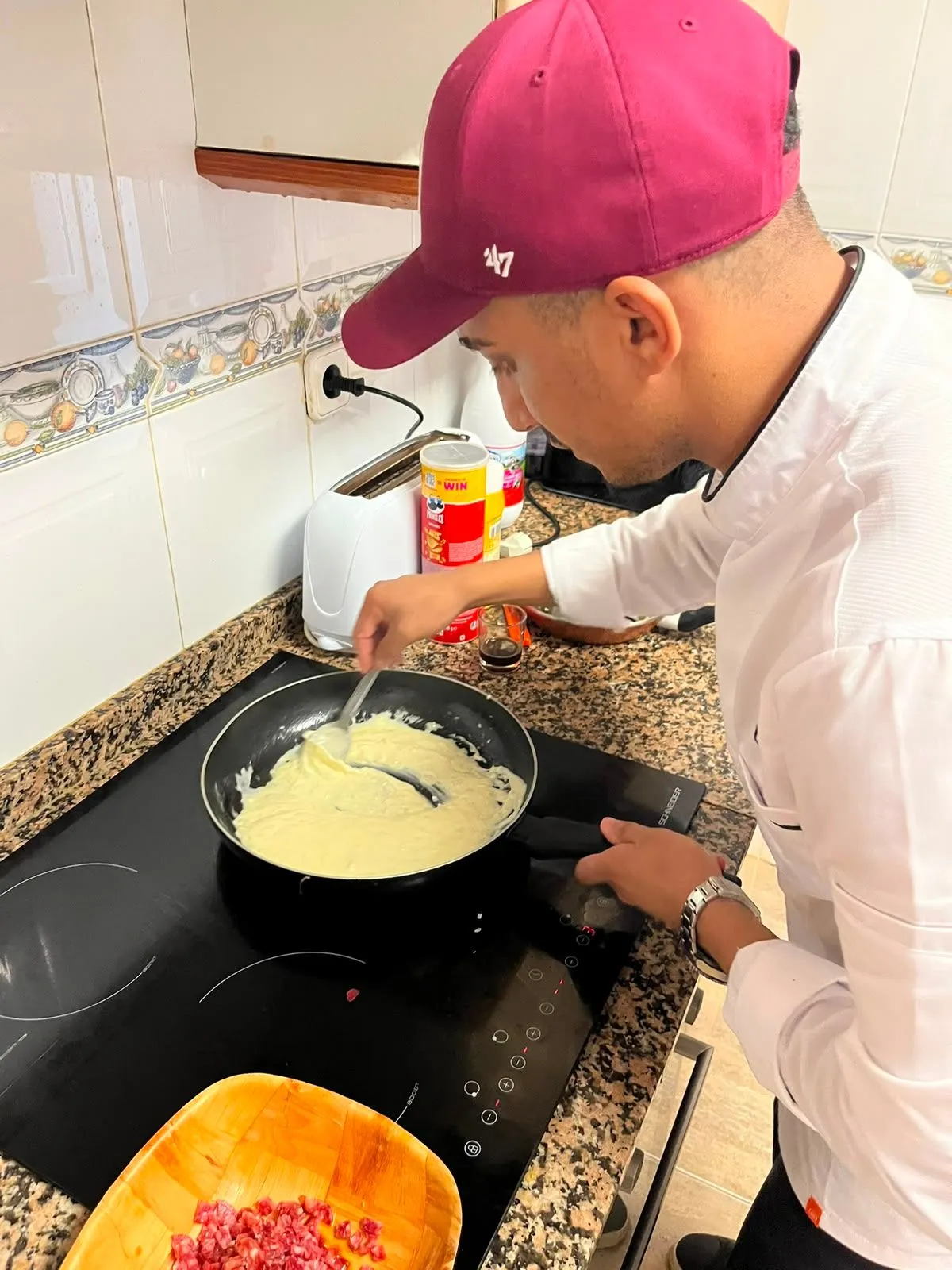 Manos del chef terminando un plato con una salsa