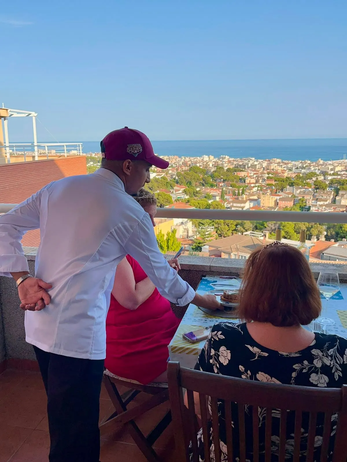 Moneim sirviendo una cena en una terraza con vistas al Mediterráneo