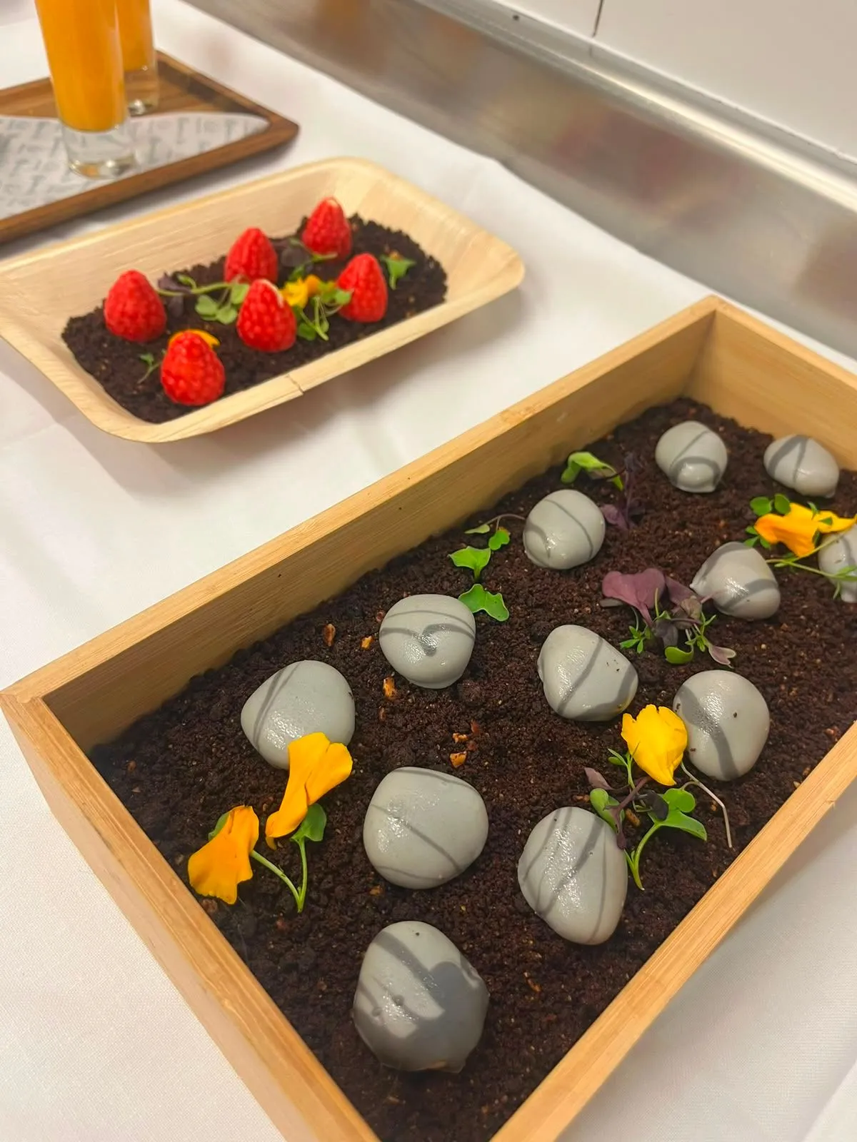 Postre en forma de piedras sobre tierra comestible con flores