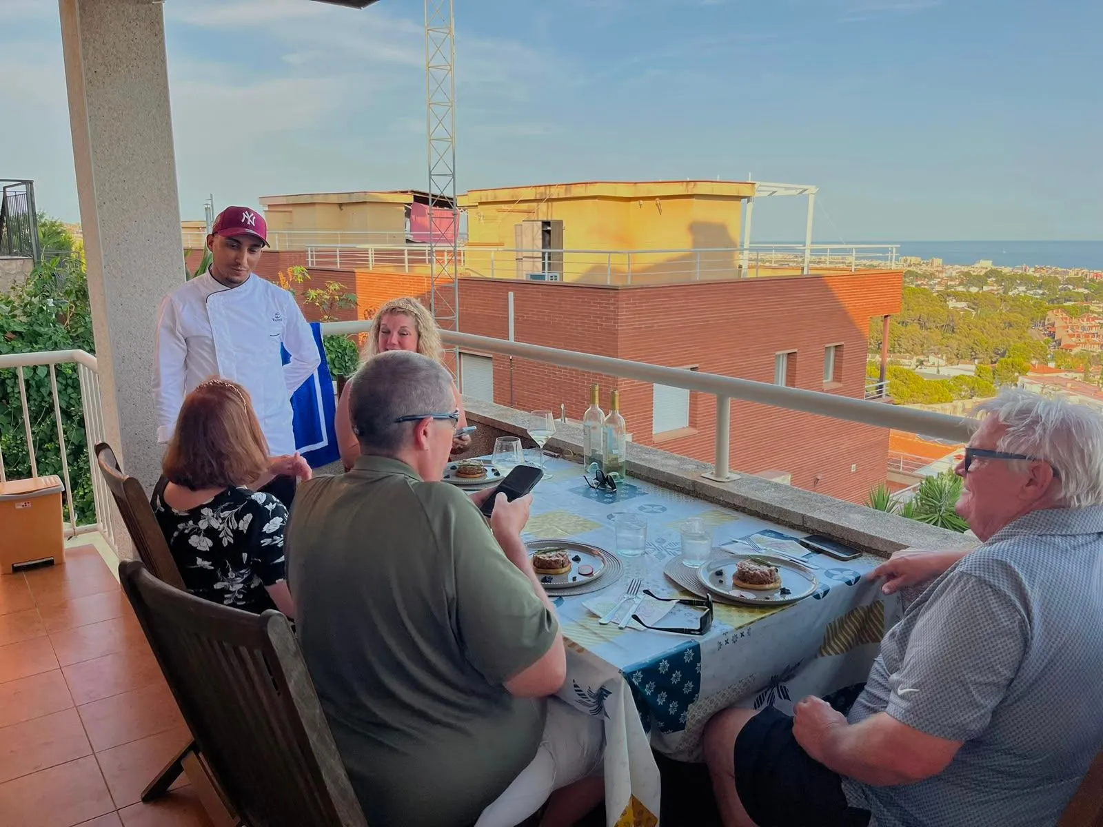 Invitados a la mesa en una terraza con vistas